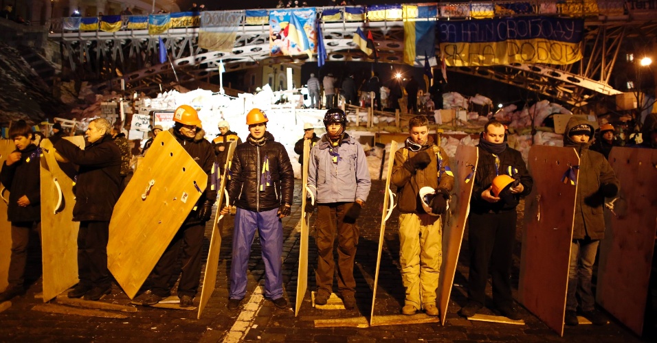 15dez2013---manifestantes-ucranianos-que-apoiam-um-possivel-acordo-com-a-ue-uniao-europeia-fazem-linha-de-defesa-contra-a-policia-na-praca-da-independencia-em-kiev-1387082699720_956x500.jpg