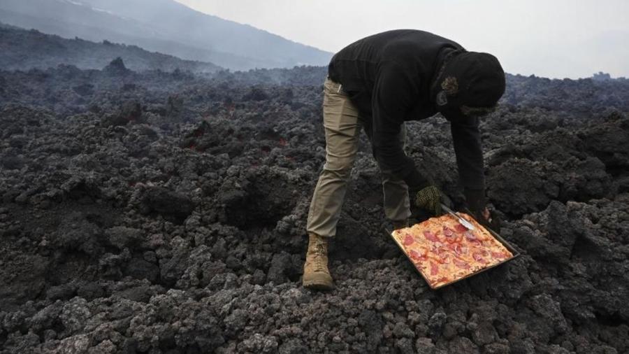 Chef cozinhando pizza em um fluxo de lava fresca do vulcão Pacaya, na Guatemala - AFP