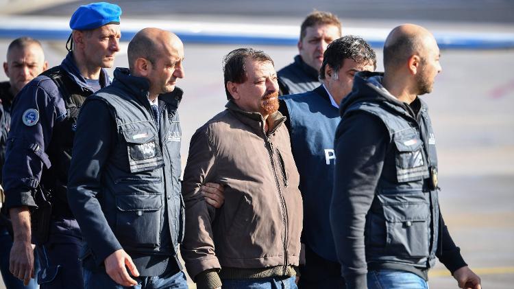 14jan2019---cesare-battisti-e-detido-por-policiais-italianos-ao-desembarcar-no-aeroporto-de-ciampino-em-roma-1547463737149_v2_750x421.jpg